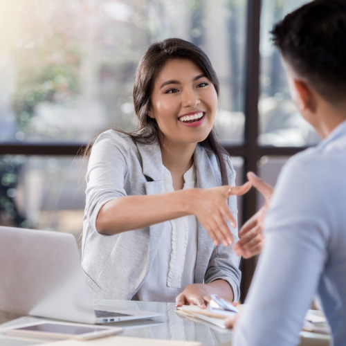 A woman and man sitting at a table talking.