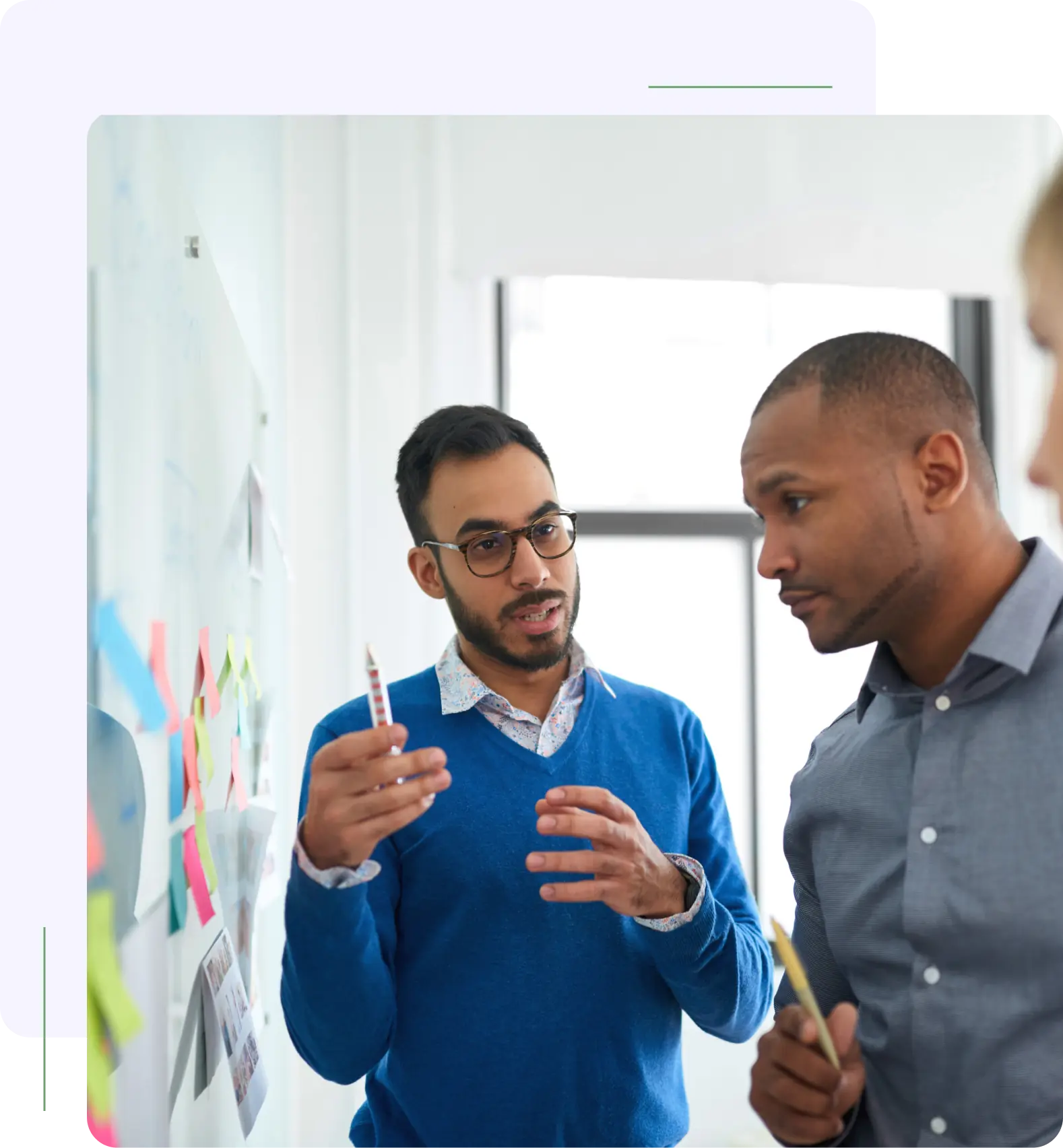 Two men and a woman are talking in an office.