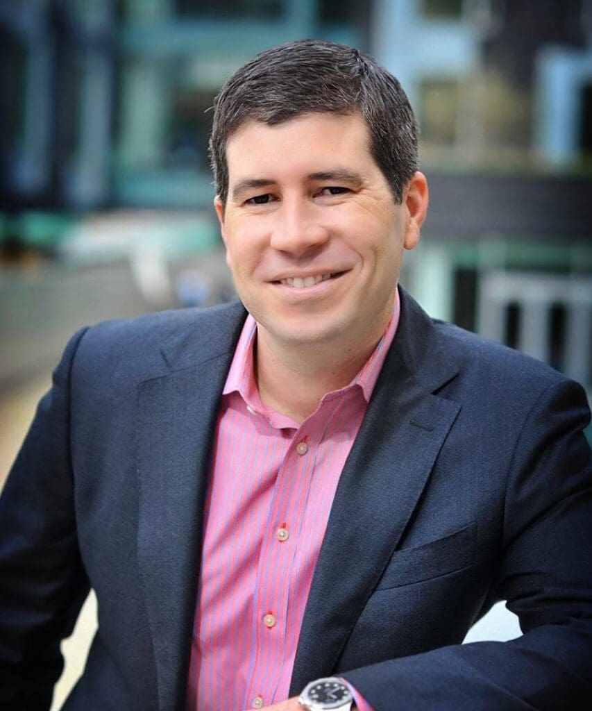 A man in a suit and pink shirt