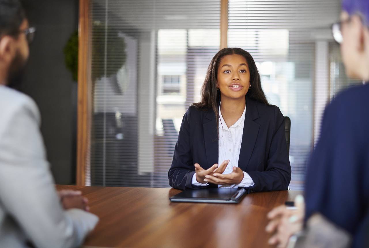 A woman sitting at a table with other people.