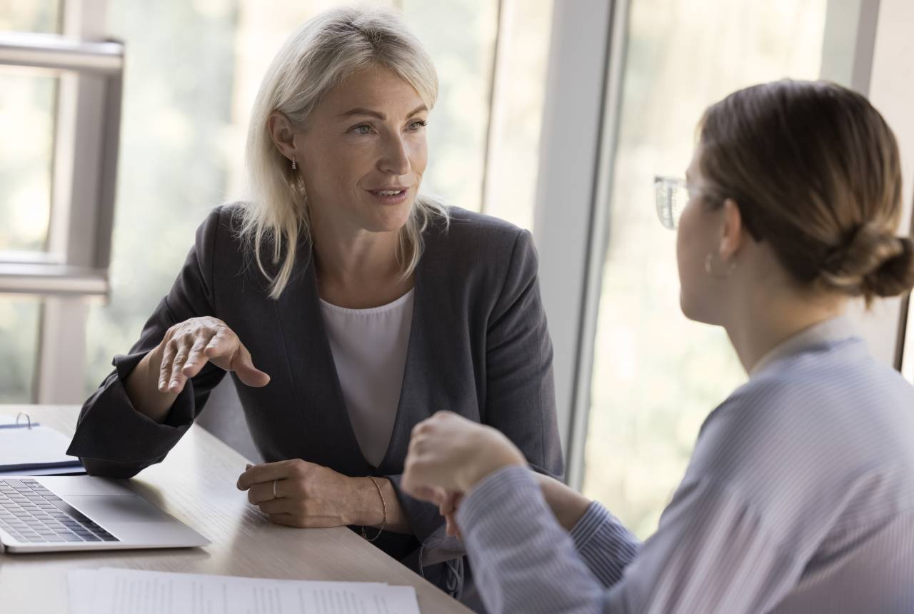 Two women are sitting at a table talking.