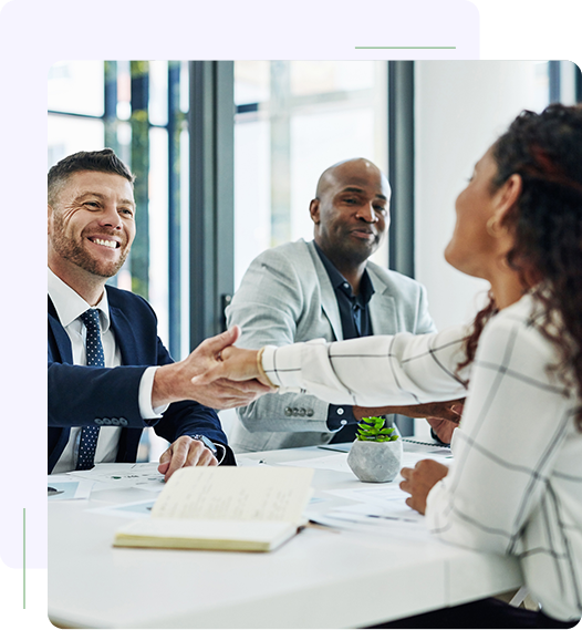 A group of people sitting around a table shaking hands.